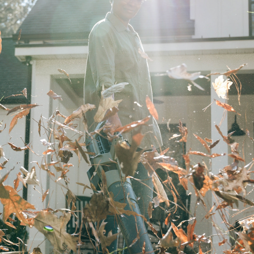 Woman blowing leaves with Green Machine blower.