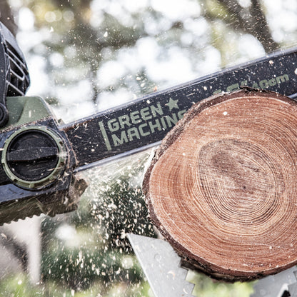 Green Machine chainsaw cutting tree trunk.
